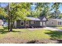Single-story home with a gray exterior, freshly cut grass, and a driveway on a sunny day at 506 W Walnut St, Selma, NC 27576