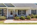 Inviting front porch features a seating area, brick columns, and well manicured landscaping at 509 Par Dr, Nashville, NC 27856
