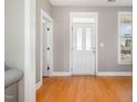 Bright entrance with hardwood floors, white door, and trim at 605 Bellefont Ct, Knightdale, NC 27545