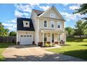 Charming two-story home with a well-manicured lawn, inviting front porch, and attached garage at 605 Bellefont Ct, Knightdale, NC 27545