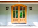 Up close view of the front door with beautiful stained wood and decorative carriage lights at 698 Maple Springs Ln, Bear Creek, NC 27207