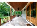 Wide, covered porch featuring stained wood columns, stained wood ceiling and outdoor seating area at 698 Maple Springs Ln, Bear Creek, NC 27207