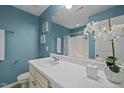 Bright bathroom with a white vanity, light blue walls, and a large mirror at 7 Faircroft Ct, Durham, NC 27703