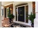 Elegant front door with decorative glass, black hardware, and potted ferns at 7620 Rainwater Rd, Raleigh, NC 27615