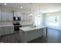 Modern kitchen with island, pendant lighting, stainless appliances and gray cabinets at 776 Shadetree Rd, Benson, NC 27504