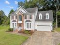 Desirable two-story home with brick details, dormer windows, and an attached garage at 8 Summertime Ct, Durham, NC 27707