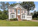 Inviting two-story home with manicured lawn, brick accents, and a two-car garage at 8 Summertime Ct, Durham, NC 27707