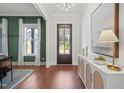 Elegant entryway with wood floors, a dark front door, and a white console table with decorative accents at 815 Laurelwood Dr, Durham, NC 27705
