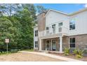 Charming two-story exterior showing a combination of brick and white siding with a quaint balcony and well-maintained landscaping at 11548 Helmond Way # 104, Raleigh, NC 27617