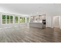 Spacious open-concept living room and kitchen with hardwood floors and large windows offering ample natural light at 11548 Helmond Way # 104, Raleigh, NC 27617