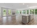 Bright, open-concept living room and kitchen with luxury vinyl plank flooring and large windows offering ample natural light at 11548 Helmond Way # 104, Raleigh, NC 27617