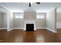 Bright living room with hardwood floors, a classic fireplace, and ample natural light from large windows at 129 Middlegreen Pl, Holly Springs, NC 27540