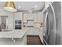 Bright kitchen with stainless appliances, granite counters, hardwood floors, and white cabinets at 1313 Littlehills Dr, Apex, NC 27523