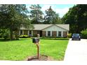 Inviting brick home with tidy landscaping, mailbox, and a paved driveway leading to a car at 1815 Chandellay Dr, Durham, NC 27705