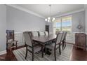 Dining room featuring a dark wood table with upholstered chairs, hardwood floors, and wainscoting at 184 Elgin Ct, Burlington, NC 27215