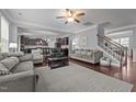 Open-concept living room with a ceiling fan and hardwood floors leading to a kitchen at 184 Elgin Ct, Burlington, NC 27215