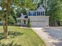 Charming two-story home with a two-car garage, well-manicured lawn, and mature trees at 221 Antique Lace Way, Holly Springs, NC 27540