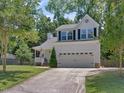 Charming two-story home with a two-car garage, well-manicured lawn, and mature trees at 221 Antique Lace Way, Holly Springs, NC 27540