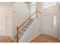 Welcoming foyer with hardwood floors, staircase with white banister, and natural light at 2644 Bloomsberry Ridge Dr, Fuquay Varina, NC 27526