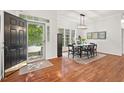 Inviting dining room with hardwood floors, a modern chandelier, and views of the outdoors at 3 Waconda Ct, Durham, NC 27713