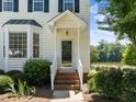 Inviting front entrance with brick steps, detailed doorframe and a view of the lake at 400 Nottinghill Walk, Apex, NC 27502