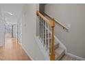 Carpeted staircase with oak banister leading to the second floor at 400 Nottinghill Walk, Apex, NC 27502
