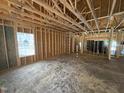 View of the unfinished interior with exposed wood beams and stud framing, showcasing the open floor plan at 4026 N Nc 581 Hwy, Kenly, NC 27542