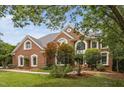 Stunning brick home showcasing architectural details, large windows, and lush landscaping for curb appeal at 409 Englewood Dr, Chapel Hill, NC 27514