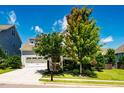 Inviting home exterior featuring a lush lawn, mature trees, and a spacious driveway at 42 Juneberry Dr, Chapel Hill, NC 27516