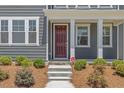 Covered front porch with stone steps and a modern front door at 4716 Crescent Square St # 1314, Raleigh, NC 27616