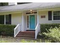 Inviting front entrance with a bright blue door, white trim, and manicured landscaping at 5112 Stephens Ln, Durham, NC 27712