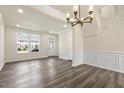 Open-concept living room featuring dark wood-look flooring, with crown molding, and large windows at 523 Berry Chase Way, Cary, NC 27519