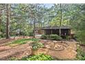 Secluded backyard with mature trees, decorative landscaping, and a view of the rear exterior of the house at 5315 Mccormick Rd, Durham, NC 27713