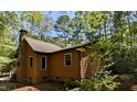 Exterior view of a home with wood siding and a brick chimney, surrounded by trees at 5315 Mccormick Rd, Durham, NC 27713