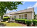 Cozy backyard with patio, striped umbrella, and lush green landscaping, perfect for outdoor relaxation at 575 Tomkins Loop, Cary, NC 27519