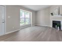 Bright living room featuring hardwood floors, a fireplace, and a large window at 5905 Westcreek Pl, Raleigh, NC 27606