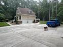Spacious two-car garage with a large driveway and ample parking, surrounded by lush greenery at 6225 Acorn Ridge Trl, Hillsborough, NC 27278