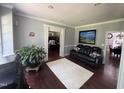 Comfortable living room featuring hardwood floors, a leather sofa, and stylish decor at 6225 Acorn Ridge Trl, Hillsborough, NC 27278