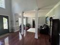 Elegant living room with hardwood floors, classic columns, and plenty of natural light at 6225 Acorn Ridge Trl, Hillsborough, NC 27278