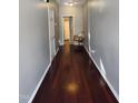 Hallway with hardwood floors and neutral paint leading to a bathroom at 650 Ganyard Farm Way # 32, Durham, NC 27703