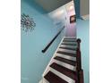 Staircase featuring wood treads and railing, with a blue accent wall at 651 Berry Chase Way, Cary, NC 27519