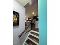 Staircase leading to kitchen with modern cabinetry and stainless appliances at 651 Berry Chase Way, Cary, NC 27519