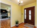 Bright foyer with yellow walls, wooden floors, classic chandelier and an ornate wooden front door at 712 E Horne St, Clayton, NC 27520