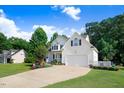 Attractive home featuring a manicured lawn, mature landscaping, and a convenient two-car attached garage at 74 Fountain Dr, Clayton, NC 27520