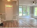 Bright and airy living room featuring large windows, wood-look floors, and classic moldings, creating an inviting space at 8100 Laurel Mountain Rd, Raleigh, NC 27613