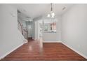 Open-concept living area with hardwood floors, staircase and view to the kitchen at 8422 Central Dr, Raleigh, NC 27613