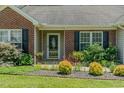 Inviting front entrance features a glass door, brick facade, and professional landscaping at 101 Kingston Ln, Graham, NC 27253