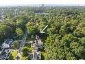 Lush, green trees surround the property in this neighborhood near a main road in an aerial view at 1021 Manchester Dr, Raleigh, NC 27609