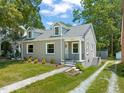 Charming grey home featuring a well-manicured lawn, dormers, and sidewalk entrance at 1022 Carolina Ave, Durham, NC 27705
