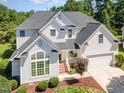 A stunning aerial view of a two-story home with lush landscaping, an attached garage, and a classic architectural style at 103 Equestrian Ct, Cary, NC 27513